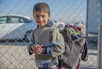الطفل مصطفى يحمل حقيبته المملوءة بأشيائه الخاصة في مخيم الخازر للنازحين في محافظة نينوى.