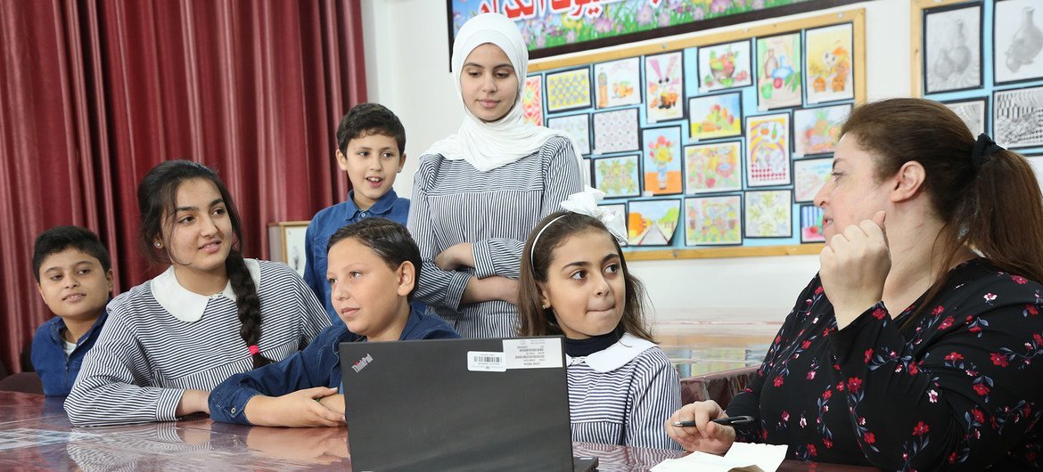 Сотрудница Службы новостей ООН Рим Абаза с детьми из числа палестинских беженцев в одной из школ БАПОР. 