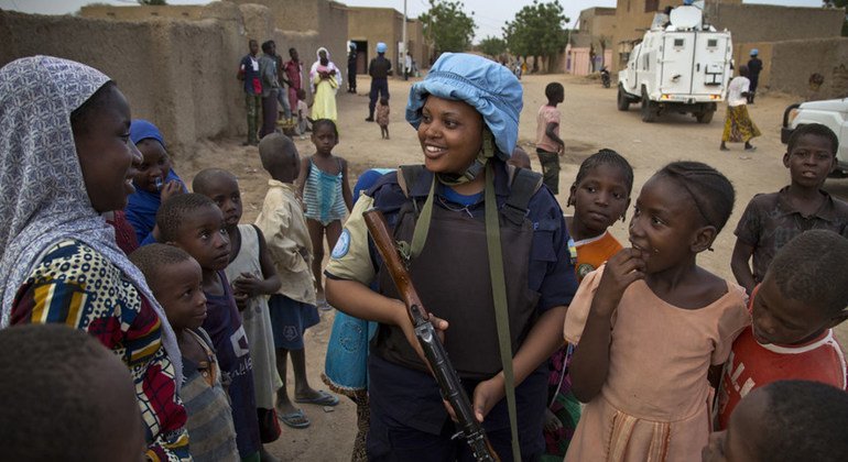 A Rwandan police officer deployed in Mali meets with civilians while patrolling the streets of Gao.