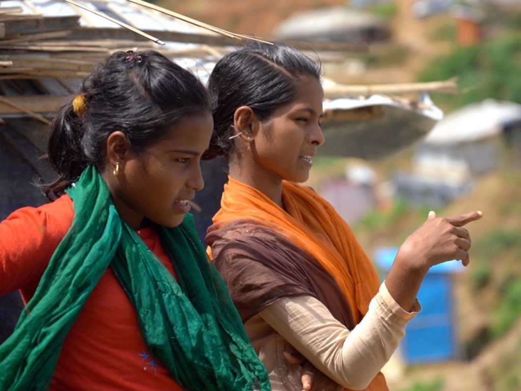 Tasmin (à droite), une étudiante bangladaise, parle à son amie Rajima (à gauche), réfugiée rohingya, au camp de réfugiés Hakimpara à Cox's Bazar, au Bangladesh (août 2018).