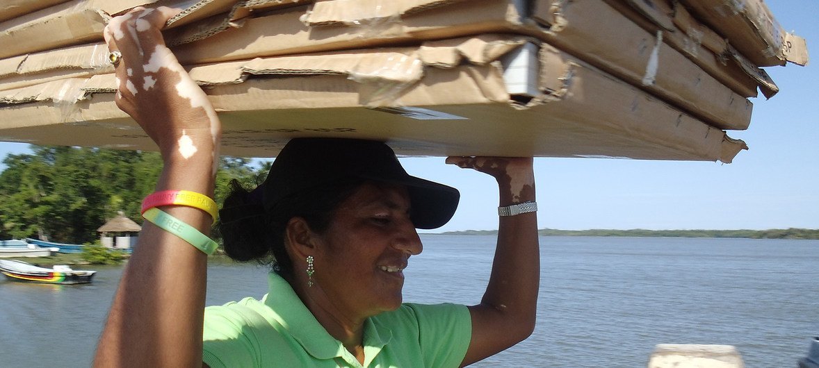 Mujer transportando paneles solares en Honduras.