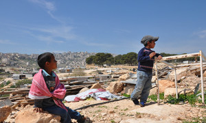 Bedouin boys living in Jabal al-Baba in the remains of their family’s home which was demolished in 2017. (file photo)