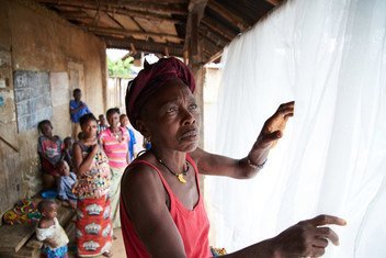 Mwanamke akifunga chandarua cha mmbu baada ya kukipokea wakati wa kampeni ya kitaifa ya ugawaji vyandarua vya mbu kwenye kijiji cha Giema Dama Wilaya ya Kenema nchini Sierra Leone , June 2017