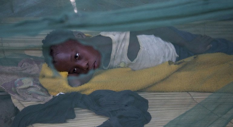 मोजाम्बिक में छेद वाली मच्छरदानी में सोने की कोशिश कर रही मलेरिया पीड़ित एक बच्ची. 