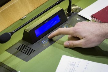 A delegate casts their vote on a report of the Special Political and Decolonization Committee (Fourth Committee) at a Plenary meeting of the General Assembly.