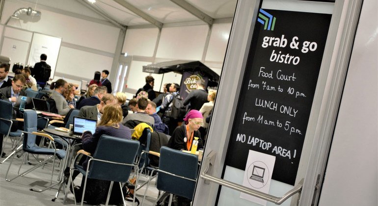 Delegados de la conferencia COP24 en Katowice, Polonia, toman un descanso en la cafetería.