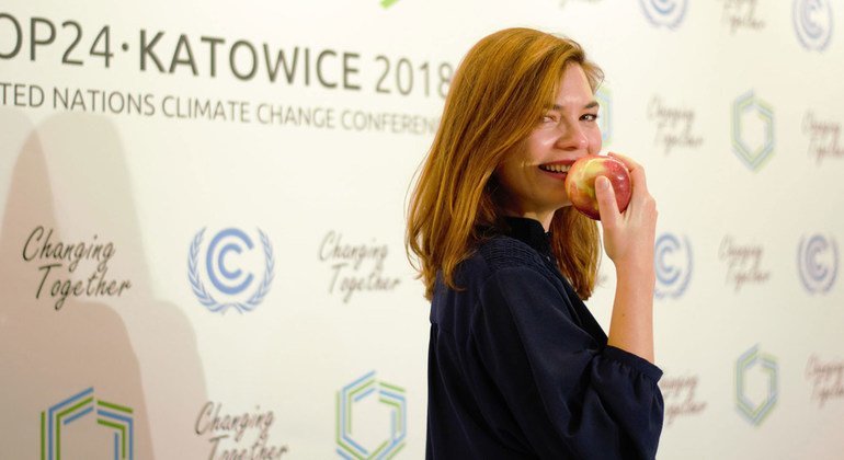 مندوبة في مؤتمر المناخ COP24 في كاتوفيتسا، بولندا تأكل تفاحة من بستان بولندي، حيث عملت الرئاسة البولندية لمؤتمر المناخ على ضمان تسليم التفاح الطازج من بساتين البلاد كل يوم.