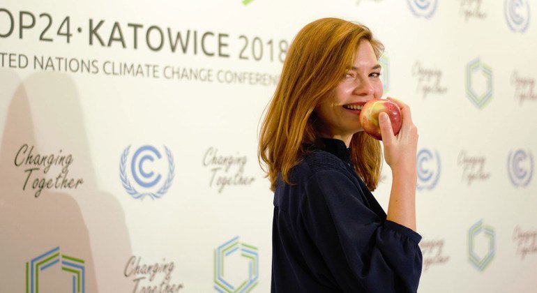 Une délégué à la conférence sur le climat de la COP24 à Katowice, en Pologne, savoure une pomme d'un verger polonais, fournie par les organisateurs de la conférence.