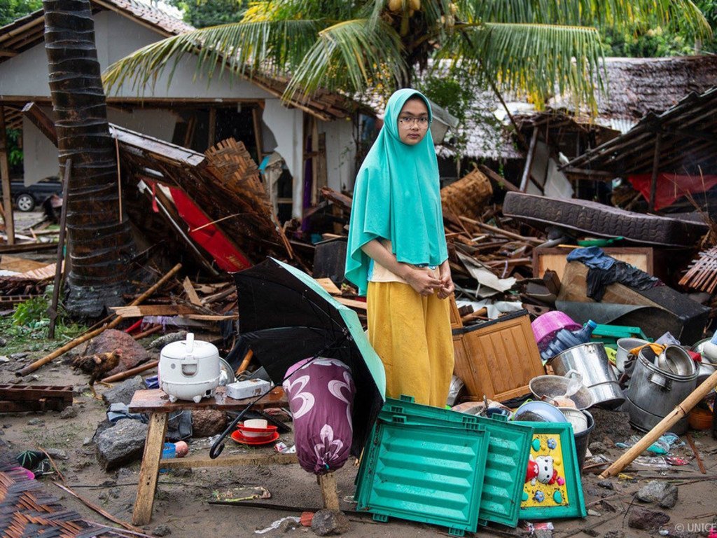 سينتا، البالغة من العمر 19 عاما، تقف وسط حطام منزلها، الذي تدمر في التسونامي، في قرية بيسوران في مقاطعة سينانكا. 24 ديسمبر 2018.