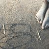 Босой южносуданский ребенок мечтает о сандалиях в лагере для беженцев в Уганде.