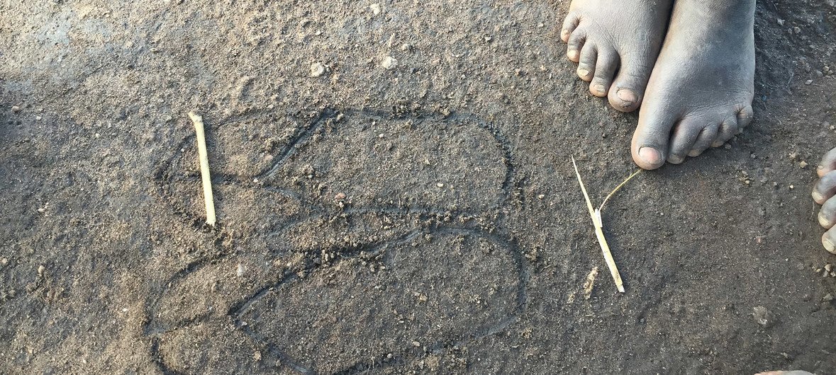 在乌干达的比迪比迪（Bidi Bidi）难民营，一名南苏丹难民儿童在沙地上画下一双他渴望拥有的拖鞋。