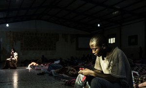 A migrant sits in a patch of light entering through one of only two windows as he tries to warm himself up at a detention centre, located in Libya, 1 February 2017. At the time of UNICEF’s visit, 160 men were being detained there.