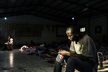 مهاجر يحاول تدفئة نفسه عبر ضوء يتسرب من خلال إحدى النافذتين الموجودتين في مركز احتجاز، في ليبيا، في 1 شباط/ فبراير 2017.  وفي الوقت الذي كانت اليونيسف تزور فيه المركز كان هناك 160 رجلاً محتجزين هناك.