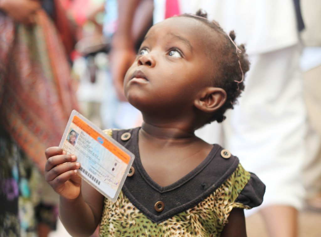  Une petite fille tenant une carte de vote lors des élections de 2011 en République démocratique du Congo (RDC).