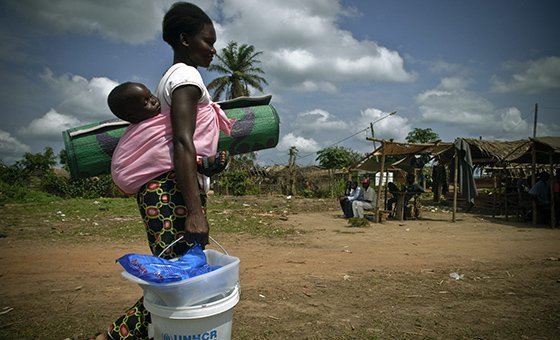 A refugee mother carries her child and relief items in Congo-Brazzaville. (file)