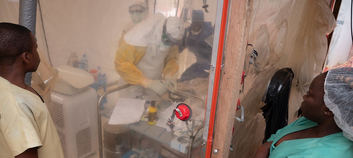 An Ebola health care worker examines a one week old infant in an isolation tent at an Ebola treatment center in Beni, North Kivu, Democratic Republic of the Congo.  3 December 2018.