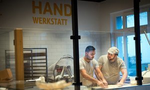 Syrian refugee Mohamad Hamza Alemam (left) is receiving baking lessons from Master baker Björn Wiese (wearing cap), at the Backwerkstatt Bakery in Eberswalde, eastern Germany.  4 December 2018.