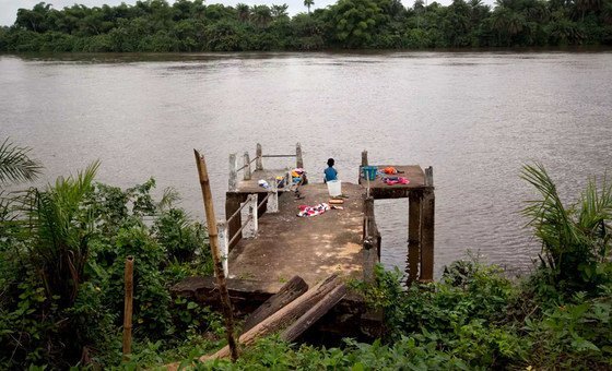 A child in Liberia sits on a pier.