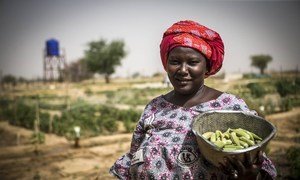 Une femme au Mali avec des légumes qu'elle a récoltés.