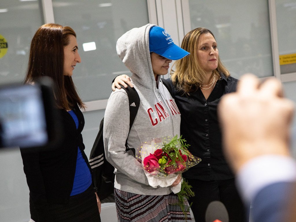 Rahaf Mohammed al-Qunun (centre), une Saoudienne de 18 ans, arrive à l'aéroport international Pearson de Toronto. Elle est accueillie par la ministre des Affaires étrangères du Canada, Chrystia Freeland (à droite), et par Saba Abbas, membre de l'ONG COSTI.