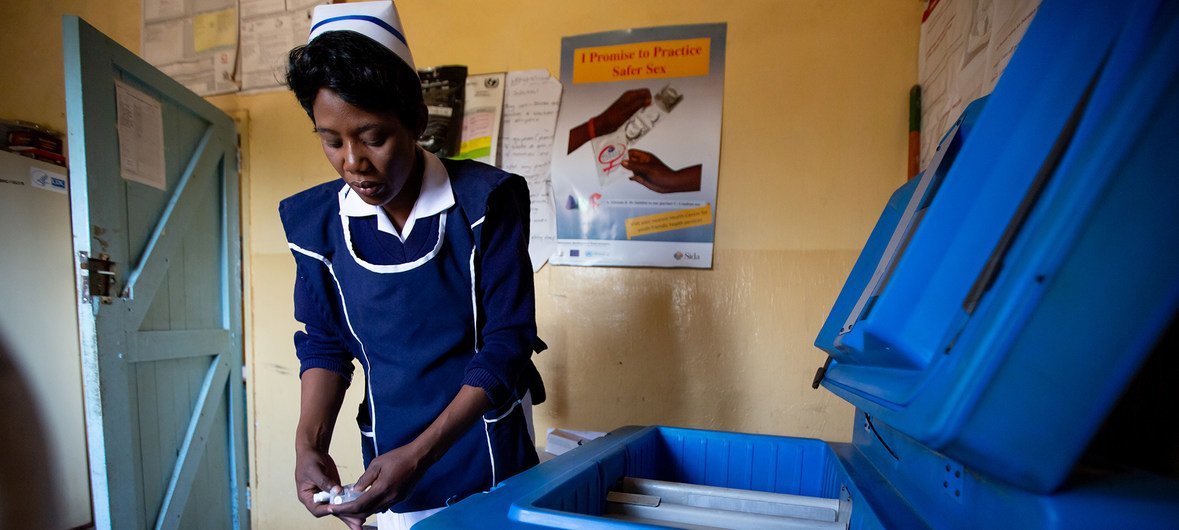 ज़ांबिया के एक अस्पताल में एक नर्स टीकाकरण की दवाइयों को फ्रिज में रखते हुए.