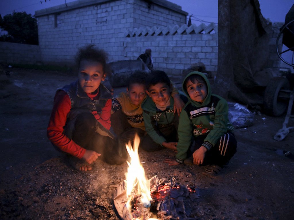 Des enfants dans le camp de Batbu, dans la région d'Alep en Syrie, brûlent des cartons et des papiers pour se réchauffer (novembre 2018). 