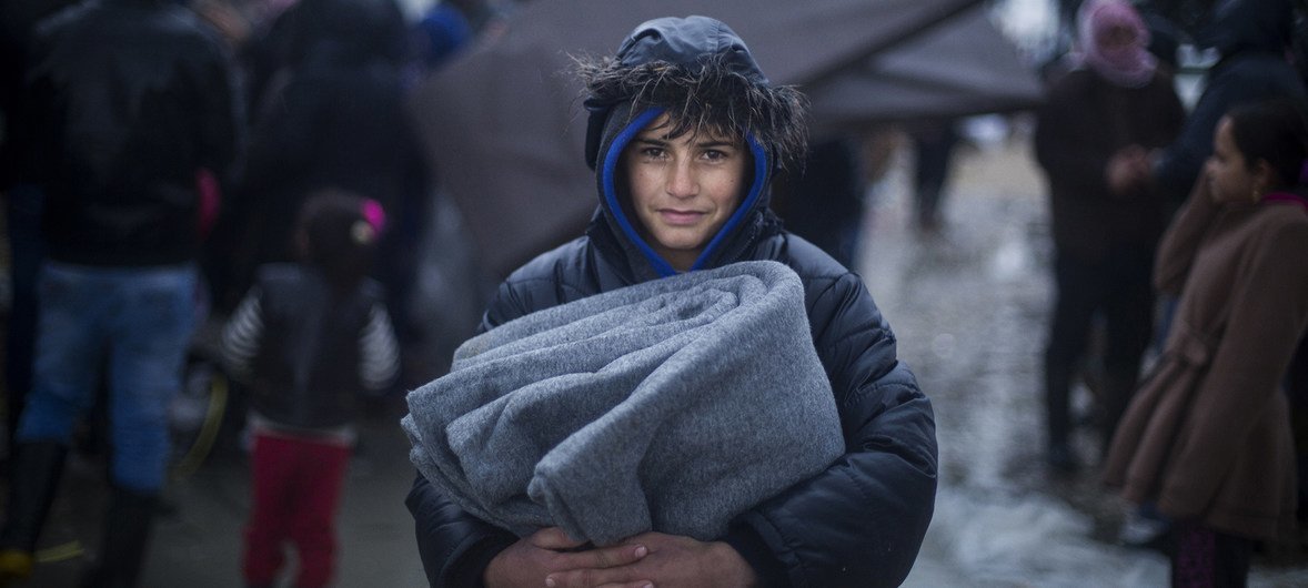 Hundreds of Syrian refugees were rescued from camps in Lebanon on Monday, as storms batter the country, causing tents and homes to flood.  Pictured is a young refugee from Deir ez-Zor carrying blankets after a UNHCR distribution. January 2019.