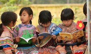 在越南偏远的老街省，土著社区的女孩们在小学校的户外一起读书。