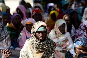 Nigerian refugee women wearing colorful headscarves sit together during an assembly at Minawai refugee camp in Cameroon.