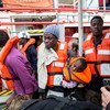 Un hombre sostiene a un niño de un año mientras desembarca de un buque de rescate con bandera holandesa. 