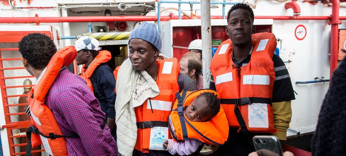 A man holding a one-year-old child disembarks from the Dutch-flagged rescue ship Sea Watch in Malta.  9 January 2019.