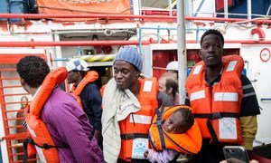 A man holding a one-year-old child disembarks from the Dutch-flagged rescue ship Sea Watch in Malta.  9 January 2019.