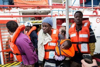 A man holding a one-year-old child disembarks from the Dutch-flagged rescue ship Sea Watch in Malta.  9 January 2019.