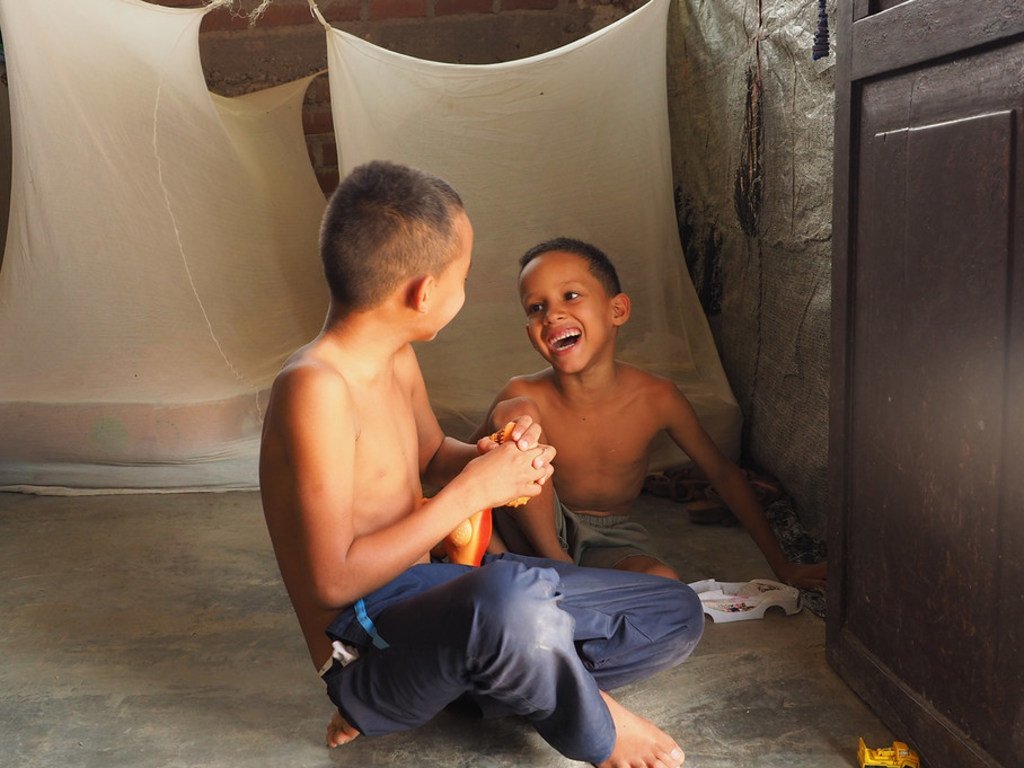 委内瑞拉的一个家庭在秘鲁的通贝斯(Tumbes)安了新家。在这里，两个孩子在他们居住的临时住所里玩耍。