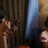 فتاة تضع مواد التجميل على وجها في كاندابارا (وهو بيت للدعارة في مدينة تانجيل في بنغلاديش). وكان رجل قد أوقع بها حيث عرض عليها أن يجد لها عملا، إلا أنه باعها إلى كاندابارا. (2009)