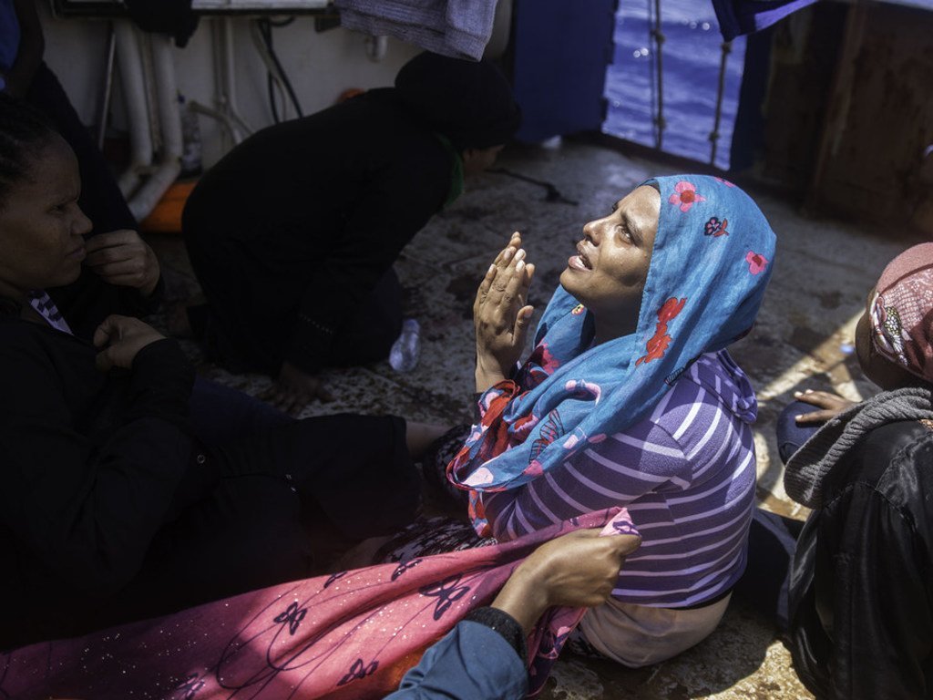 一名来自埃塞俄比亚的妇女在利比亚被从海上救起后不禁开始祈祷。