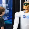 An attendee of the USA Science and Engineering Festival (2014) observes NASA's first dexterous humanoid robot  Robonaut 2, at the NASA Stage. At the time R2 had recently received 1.2 meter long legs to allow mobility.
