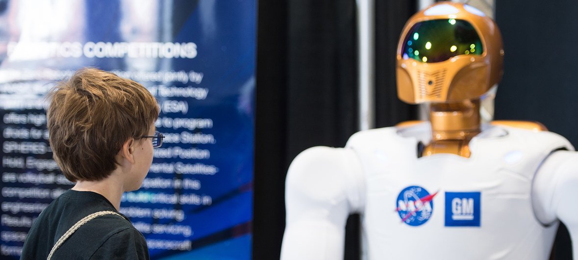 An attendee of the USA Science and Engineering Festival (2014) observes NASA's first dexterous humanoid robot  Robonaut 2, at the NASA Stage. At the time R2 had recently received 1.2 meter long legs to allow mobility.