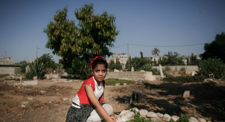 Una niña en Rafah, en la Franja de Gaza, se arrodilla sobre la tumba de su madre y hermanos.