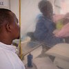 Thomas Kakule Manole observa enquanto um sobrevivente do Ebola se preocupa com sua filha de uma semana, Benedicte, em uma tenda de isolamento em um centro de tratamento de Ebola em Beni