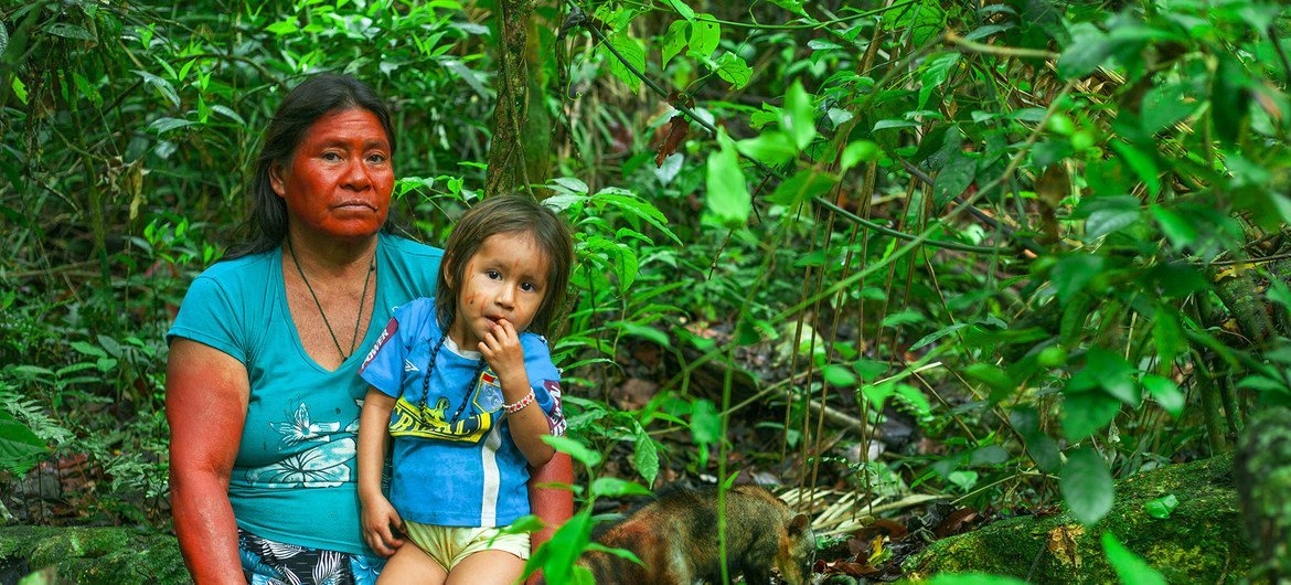 पेरू के वनों में एक आदिवासी महिला अपनी बच्ची के साथ.