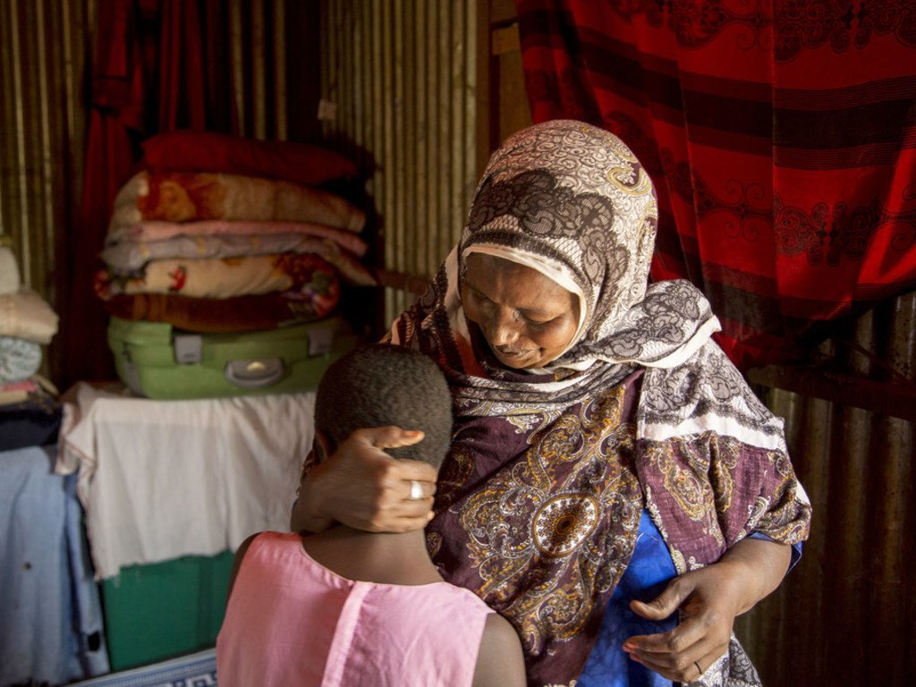 Une femme pratiquant les mutilations génitales féminines avec sa petite-fille âgée de 10 ans, à Diaami, au Somaliland (Somalie). La fillette devait subir une mutilation mais elle est malade à cause d'une infection et sa grand-mère préfère attendre.