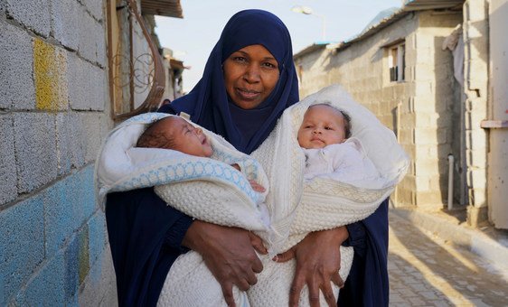 Haleema, de 42 anos, segura seus dois filhos gémeos, em campo de deslocados internos em Tawergha