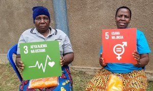 Dans un centre appuyé par UNFPA en Tanzanie, deux anciennes « coupeuses » pratiquant la mutilation génitale féminine montre les Objectifs de développement durable numéro 3 (bonne santé et bien-être) et 5 (égalité des sexes)