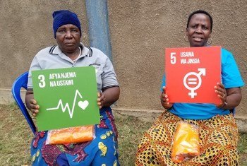 Dans un centre appuyé par UNFPA en Tanzanie, deux anciennes « coupeuses » pratiquant la mutilation génitale féminine montre les Objectifs de développement durable numéro 3 (bonne santé et bien-être) et 5 (égalité des sexes)