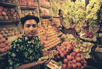 A vendor sells produce at his stall in Bangladesh. 