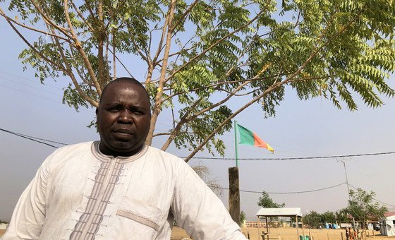 Luka Isaac, a Nigerian refugee representative in the Minawao camp in Cameroon, stands beneath a tree he planted as part of the planting of some 50,000 trees at a camp for Nigerian refugees in the far north-east corner of Cameroon. 