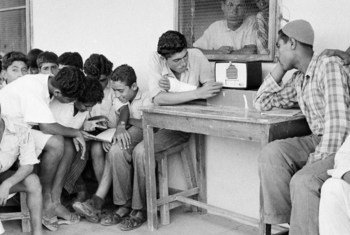 أرشيف صور الأمم المتحدة: لاجئون فلسطينيون في قطاع غزة يستمعون إلى الإذاعة. 1 يناير/كانون الثاني 1954.