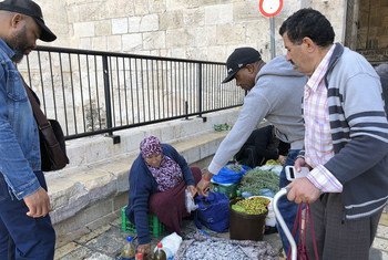 Une Palestinienne vendant des olives, de l'huile d'olive et d'autres produits alimentaires devant la porte de Damas, l'une des portes de la vieille ville de Jérusalem. Novembre 2018.