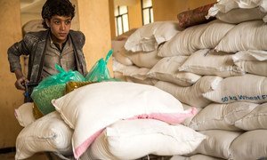 A boy pushes a wheelbarrow containing food rations from WFP at a food distribution point in the Yemeni capital, Sana’a, on 3 February 2019.